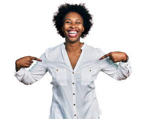 African american woman with afro hair pointing with fingers to herself smiling and laughing hard...
