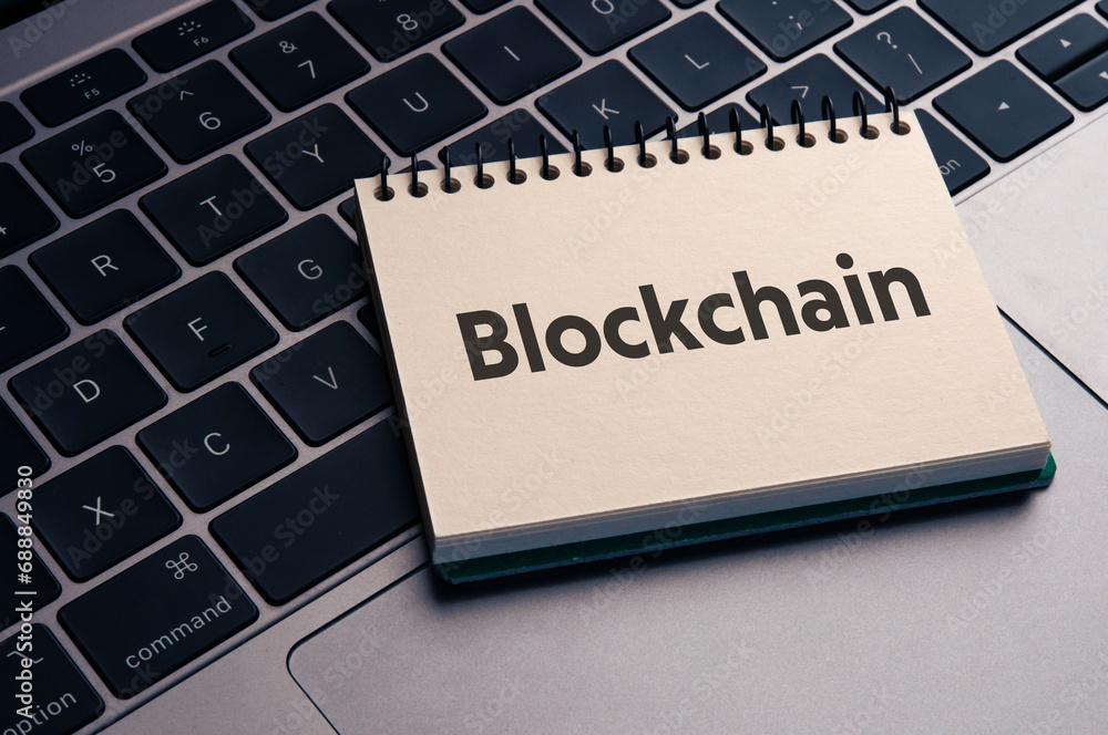Poster there is notebook with the word blockchain. it is as an eye-catching image.