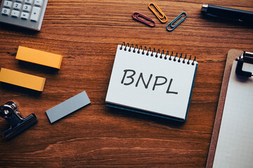 There is notebook with the word BNPL. It is an abbreviation for Buy Now, Pay Later as eye-catching image.