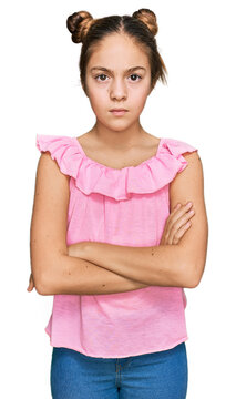 Beautiful brunette little girl wearing summer pink shirt skeptic and nervous, disapproving expression on face with crossed arms. negative person.