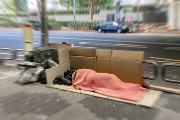 歩道上に置かれたホームレスの荷物とホームレス