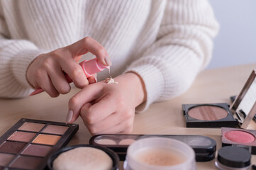 Fototapeta na wymiar Close-up of makeup artist's hands among cosmetics. 