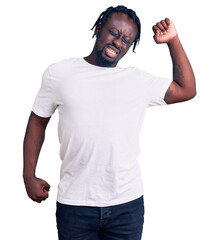 Young african american man with braids wearing casual white tshirt stretching back, tired and relaxed, sleepy and yawning for early morning