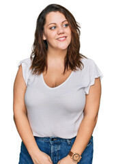 Fototapeta premium Young plus size woman wearing casual white t shirt smiling looking to the side and staring away thinking.