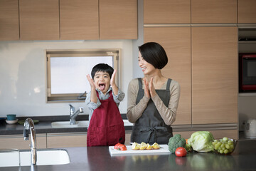 野菜大好きな子供　ママと一緒に料理をする子ども 拍手する