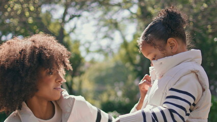 African american woman daughter enjoying sunny weekend in green park close up.