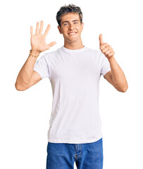 Young handsome man wearing casual white tshirt showing and pointing up with fingers number six while smiling confident and happy.