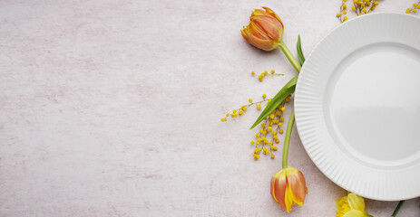 Beautiful table setting with fresh spring flowers on light grunge background with space for text