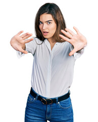 Young caucasian girl wearing casual white shirt doing frame using hands palms and fingers, camera perspective