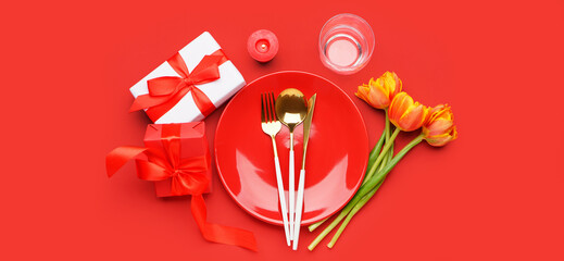 Beautiful table setting with fresh spring flowers and gifts on red background