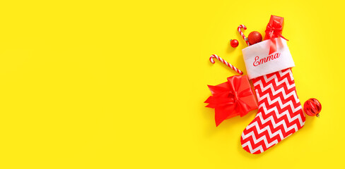 Beautiful Christmas sock with gifts and decorations on yellow background with space for text