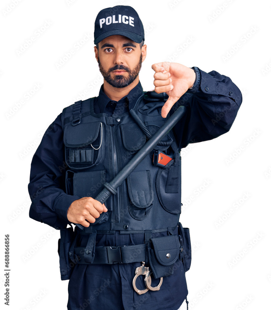 Canvas Prints Young hispanic man wearing police uniform holding baton with angry face, negative sign showing dislike with thumbs down, rejection concept