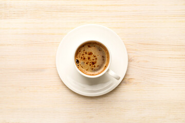 Cup of hot coffee on wooden table, top view