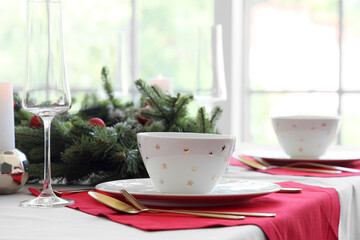 Christmas table setting with clean dishes and fir tree branches, closeup