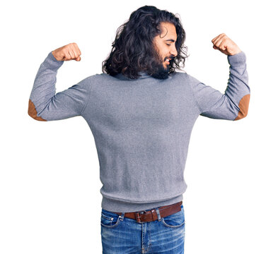 Young arab man wearing casual clothes showing arms muscles smiling proud. fitness concept.