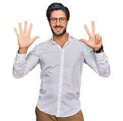 Fototapeta premium Young hispanic man wearing business shirt and glasses showing and pointing up with fingers number eight while smiling confident and happy.