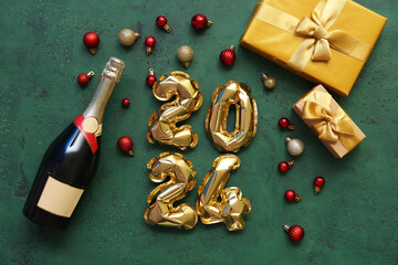 Figure 2024 made of balloons with Christmas decorations and champagne bottle on green background