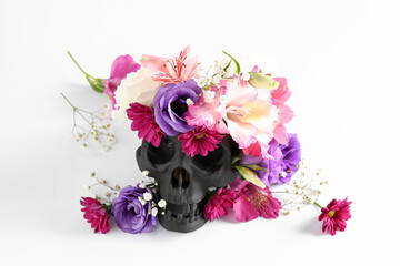 Black human skull with beautiful flowers on white background