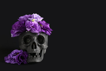 Human skull with beautiful eustoma flowers on black background