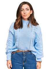 Young brunette woman wearing casual winter sweater relaxed with serious expression on face. simple...