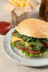 Tasty vegetarian burger with spinach cutlet, cheese and vegetables served on white table, closeup