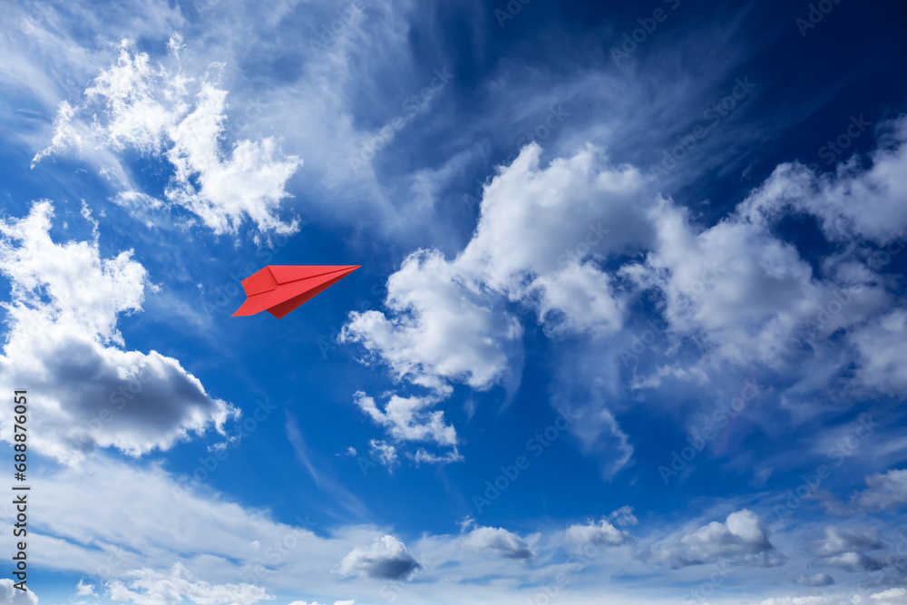 Sticker Red paper plane flying in blue sky with clouds