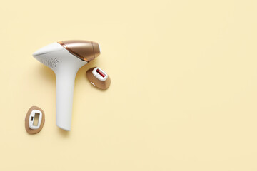Modern photoepilator with attachments on beige background