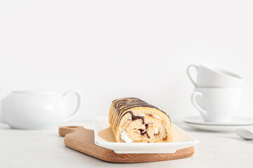 Plate with sweet sponge cake roll on white background