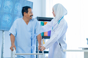 A Muslim Female doctor help a patient who is doing physical therapy and is practicing walking with...