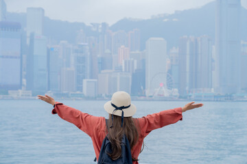 Asian tourist, cute woman with long hair are traveling in Hong Kong along with map and her camera...