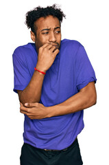 Young african american man with beard wearing casual purple t shirt looking stressed and nervous...
