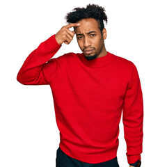 Young african american man with beard wearing casual winter sweater pointing unhappy to pimple on...