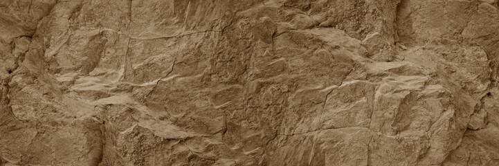 Light pale brown dark beige stone texture background. Rough rock mountain surface. Nature. Close-up. Vein cracks. Empty space. Design. Wide banner. Panoramic.