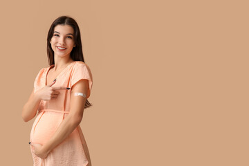 Young pregnant woman after vaccination on beige background