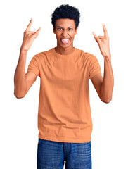 Young african american man wearing casual clothes shouting with crazy expression doing rock symbol with hands up. music star. heavy music concept.