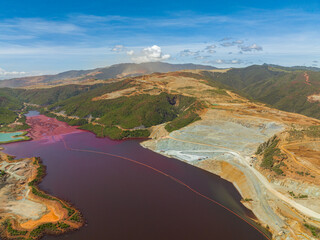 Open pit nickel mine and red water lake. Environmental issues and pollution. Mindanao, Philippines.