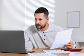Man doing taxes at table in room