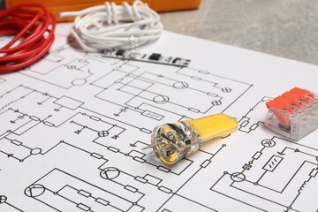 Wiring diagram, wires and other electrician's equipment on grey table, closeup