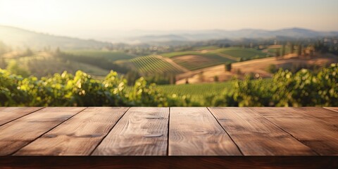 Wooden table overlooking a lush vineyard at sunset, suitable for winery and travel marketing. - obrazy, fototapety, plakaty