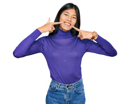 Beautiful young asian woman wearing casual clothes smiling cheerful showing and pointing with fingers teeth and mouth. dental health concept.
