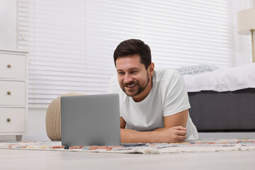 Happy man having video chat via laptop at home