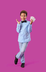 Little African-American boy with playing cards on purple background