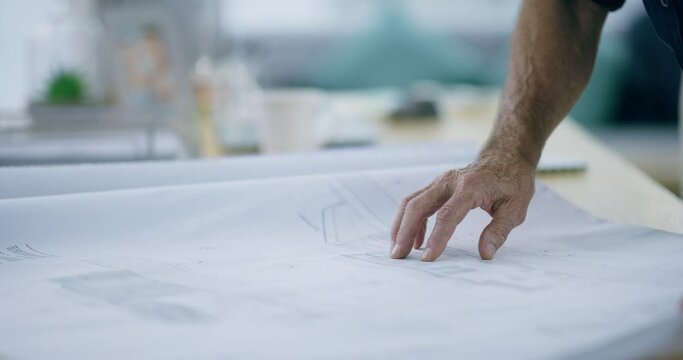 Architecture, designer and hands of man with blueprint for construction, building layout or project management. Closeup, engineering and paperwork of floor plan, infrastructure or property renovation