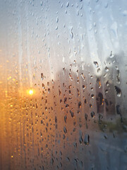 Closeup of Beautiful Rain drop on the window glass after the rain with golden light sunset blurred bokeh background at Thailand.