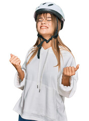 Teenager caucasian girl wearing bike helmet very happy and excited doing winner gesture with arms raised, smiling and screaming for success. celebration concept.