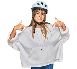 Teenager caucasian girl wearing bike helmet looking confident with smile on face, pointing oneself with fingers proud and happy.