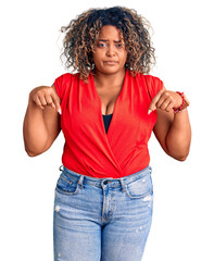 Young african american plus size woman wearing casual style with sleeveless shirt pointing down...