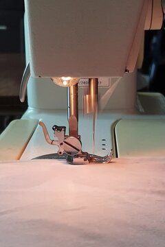 close up of sewing machine ,person stitching straight line on fabric