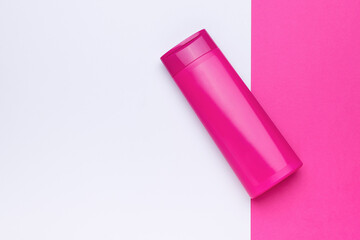 A large cosmetic bottle on a two-tone background.