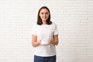 Pretty young woman with kipa on white brick wall background. Hanukkah celebration